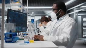 Lab scientist removing protective face mask to scratch beard while using PC. Expert wearing medical mask in contagious workspace studies DNA strand mapping with genomics analysis program, camera A - Powered by Shutterstock - Get 15% off with code: PIKWIZARD15