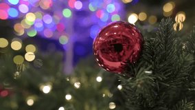 Red bell ornament on Christmas tree with colorful glowing bokeh lights - Powered by Shutterstock - Get 15% off with code: PIKWIZARD15