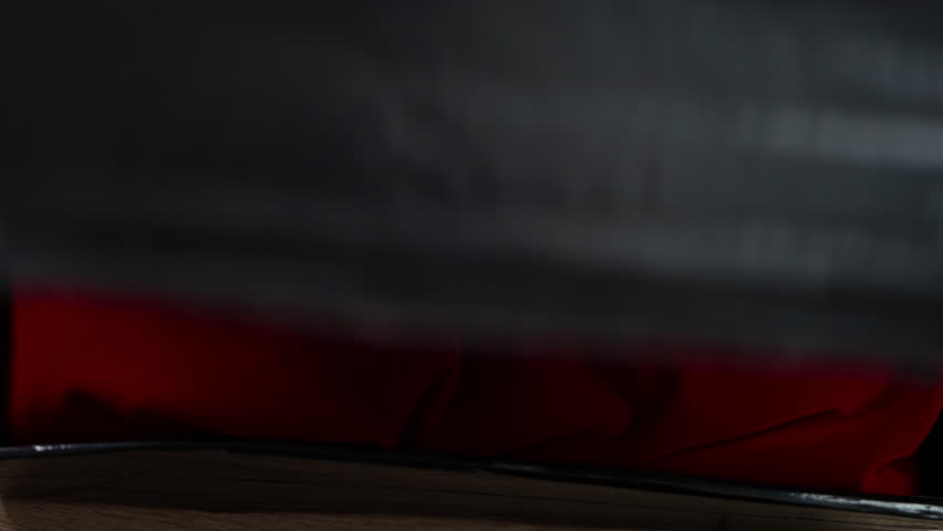 A USB drive lying on an expensive red cloth is captured in slow motion in high definition. This could be very valuable incriminating evidence or data on currency transactions.