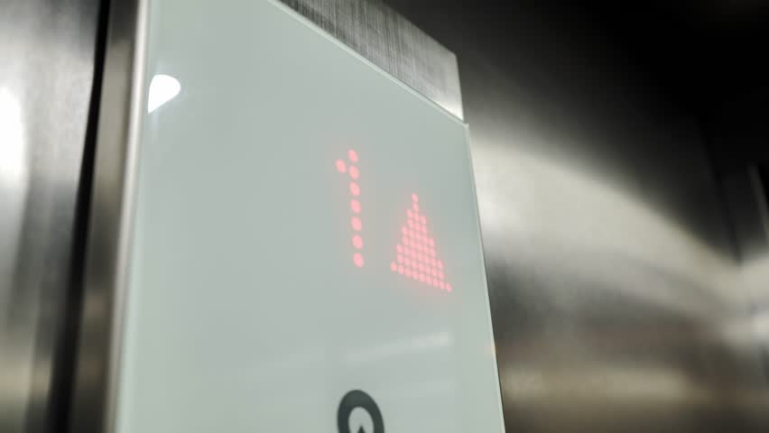 Close up, elevator control panel showing illuminated floor display moving upward