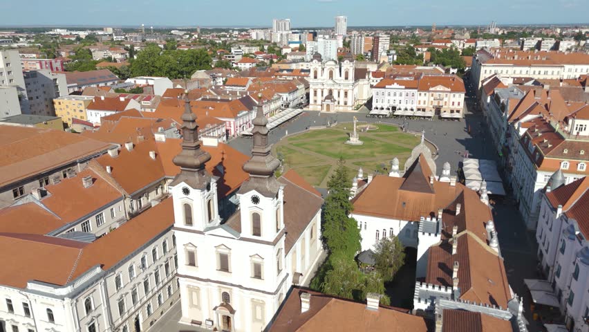 Aerial drone footage orbiting Union Square in Timisoara, Romania, highlighting the Serbian Orthodox Cathedral and the surrounding historic square.