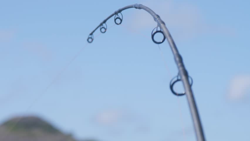 View of a fishing rod running a lure from the aft of a commercial fishing charter boat operating in the Torres Strait islands, Australia. Clip 5