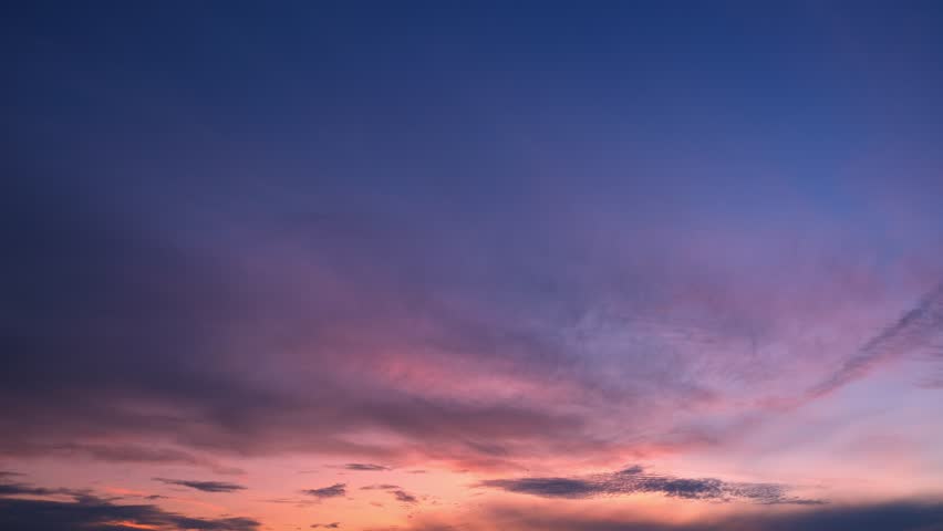 A beautiful sunrise sky timelapse video showing golden and pink clouds spreading across a soft blue horizon, capturing the gentle transition from night to the radiant warmth of dawn. Time-lapse. 4k.
