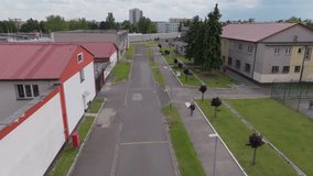 Aerial medium shot revealing prison yard, guard towers, and fenced walls under daylight. - Powered by Shutterstock - Get 15% off with code: PIKWIZARD15