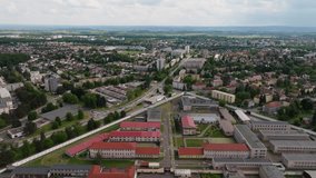 Slow aerial push-in shot over concrete prison complex with guard towers and surrounding barbed wire. - Powered by Shutterstock - Get 15% off with code: PIKWIZARD15