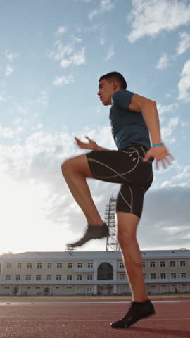 athlete man jogging on stadium at sunrise vertical slow motion fullHD morning training discipline motivation energy healthy lifestyle focus movement balance power freedom inspiration