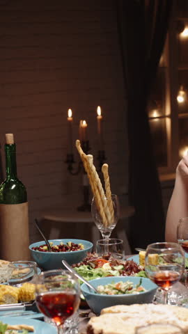 Vertical slow motion video hands exchanging gift boxes over festive dinner table concept christmas holiday celebration friendship gratitude joy cozy home warm light family gathering