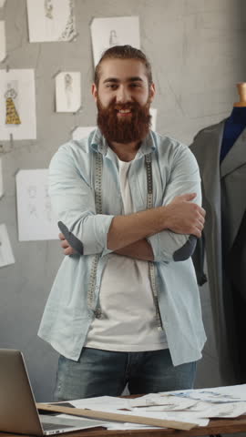 happy male fashion designer smiling at camera in modern atelier symbol of creative independence purpose fulfillment sustainable success vertical slow motion fullhd video