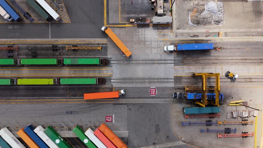 Aerial view of cargo trucks and freight trains at logistics terminal in 7 October 2025