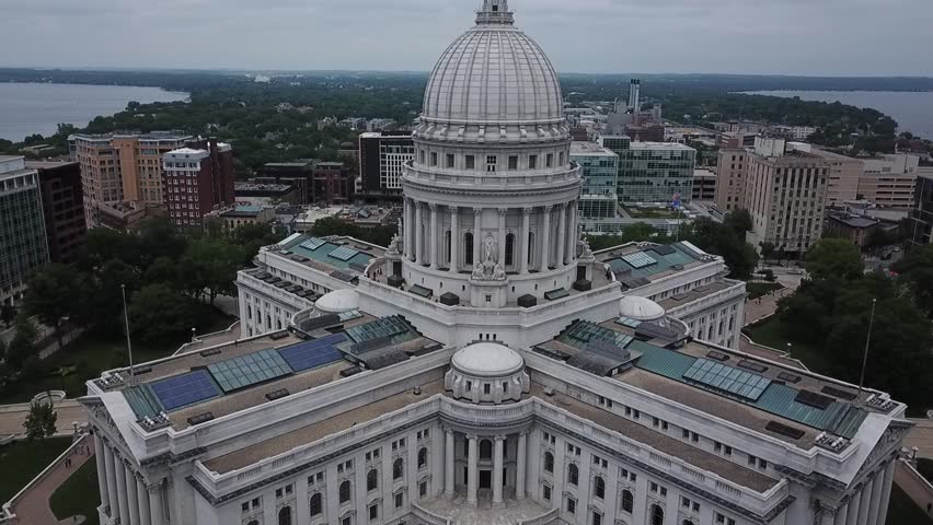 Aerial drone video of a state capitol building in Madison, Wisconsin as the drone flies to the left.