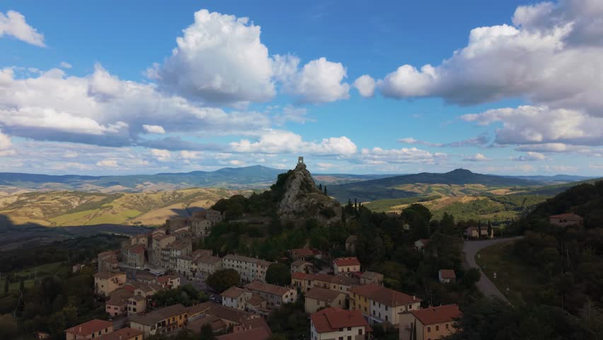 Iconic Rocca di Campiglia d’Orcia, Tuscany, Italy in golden sunlight. Wide aerial orbit at Val d'Orcia