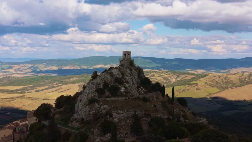 Chapel tower hill of Campiglia d’Orcia watches over Val d’Orcia countryside, Tuscany, Italy. Aerial
