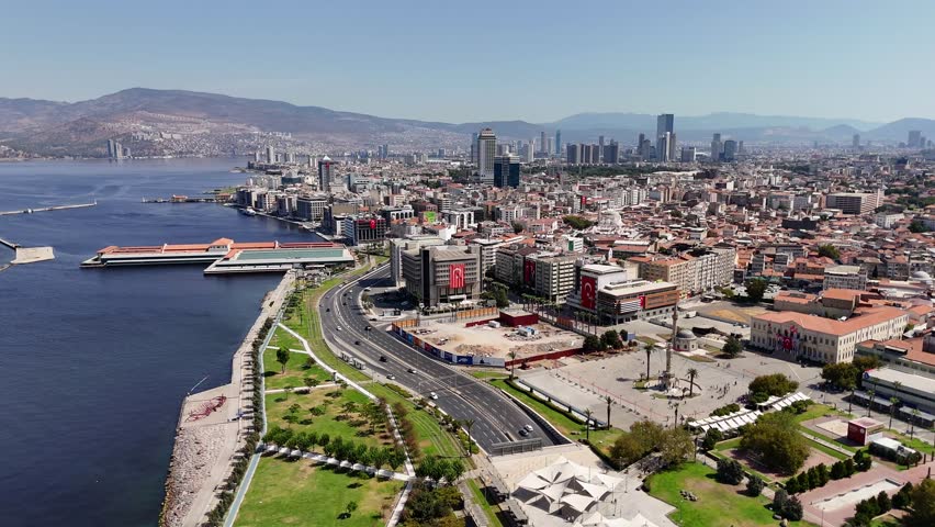 Aerial view of Izmir city in Turkey showing coastline, skyscrapers, and Konak Square on a sunny day. Clock Tower