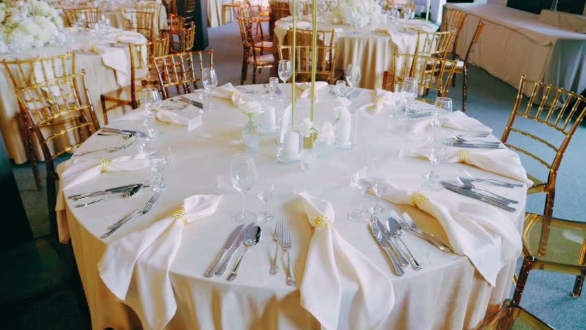 Beautifully decorated round tables with elegant cutlery, glassware, and dinnerware — sophisticated setup for wedding, banquet, or formal dining event.