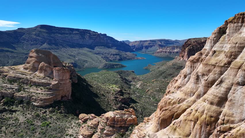 Aerial view of the Apache Trail showcasing the rugged terrain and shimmering Canyon Lake nestled amidst the arid landscape, Apache Junction, Arizona, United States.