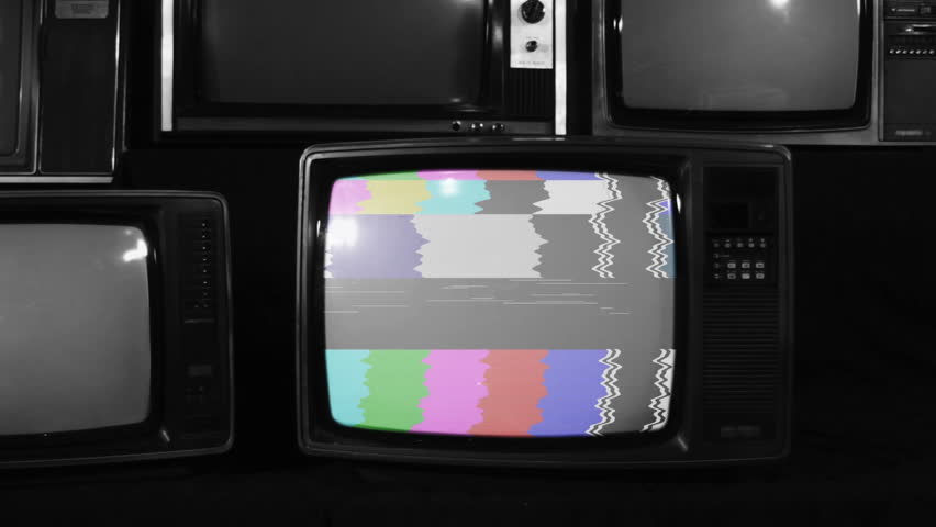 Black and White Retro TV Turning On with Green Screen, Surrounded by Old Turned Off Televisions - Close Up