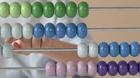 Close-up of a child finger moving yellow beads on colorful abacus. Macro view emphasizes tactile learning, fine motor skills, and playful exploration of numbers in a bright, educational environment. - Powered by Shutterstock - Get 15% off with code: PIKWIZARD15