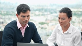 Business partner working together on a laptop during an informal meeting on an outdoor terrace with a cityscape background. Man and woman collaborating on strategy, finance, and career development - Powered by Shutterstock - Get 15% off with code: PIKWIZARD15
