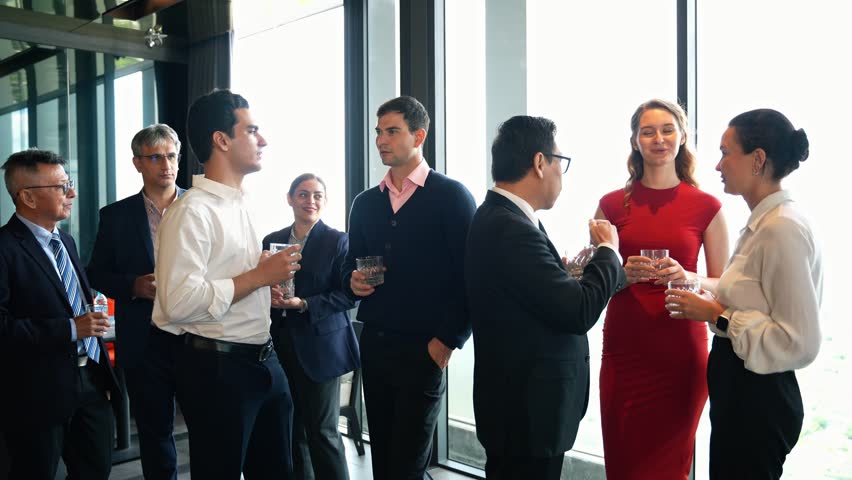 Diverse group of happy business professionals networking and socializing at a corporate cocktail event or New year party. Colleagues enjoy conversation and build relationships during meeting at lounge