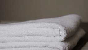 Close-up of hands placing white bath towels on the bed sheet. Concept of room cleaning service. - Powered by Shutterstock - Get 15% off with code: PIKWIZARD15