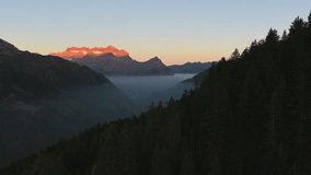 Sunrise light brightens Swiss Alps above a misty valley. Calm aerial view of mountains and fog in morning glow. - Powered by Shutterstock - Get 15% off with code: PIKWIZARD15