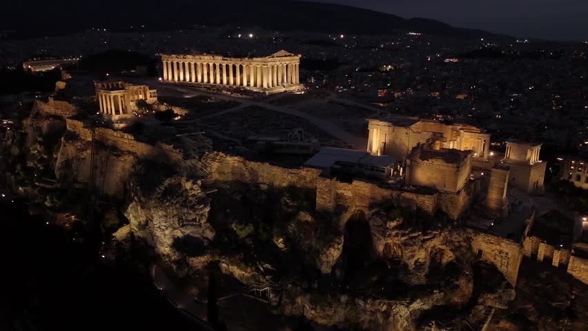 Athens, Aerial view of Beautifully illuminated Acropolis at night, circle pan right slowly from a distance,Full view of Panthenon,Erechthenion and entrance of Acropolis in shimmering lights.