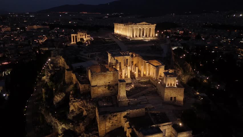 Athens, Aerial view forward towards Beautifully illuminated Acropolis at night. Full view of Panthenon,Erechthenion and entrance of Acropolis in shimmering lights.