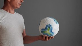 A man is playing with a soccer ball, juggling it effortlessly with focused concentration in a simple indoor setting - Powered by Shutterstock - Get 15% off with code: PIKWIZARD15