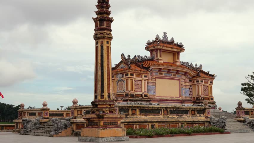 The towering Dai Hong Mon gate at the Lang Minh Mang Imperial Tomb in Hue, showcasing intricate Vietnamese Imperial architecture beneath an overcast sky.