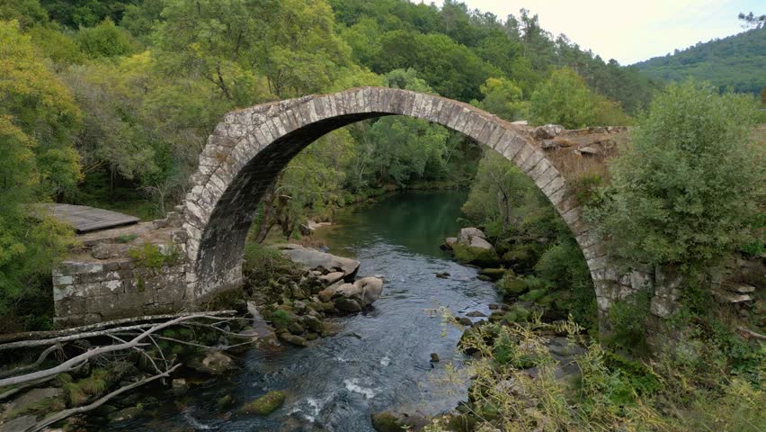 Isolated Stone Arch Bridge Over Flowing River Of Avia Near Cenlle, Ourense Province, Spain. Aerial Shot