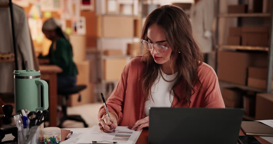 Woman, writing and laptop for ecommerce logistics, delivery and shipping info in fashion business. Person, taking notes with computer in retail office for sale, packaging details and courier service.