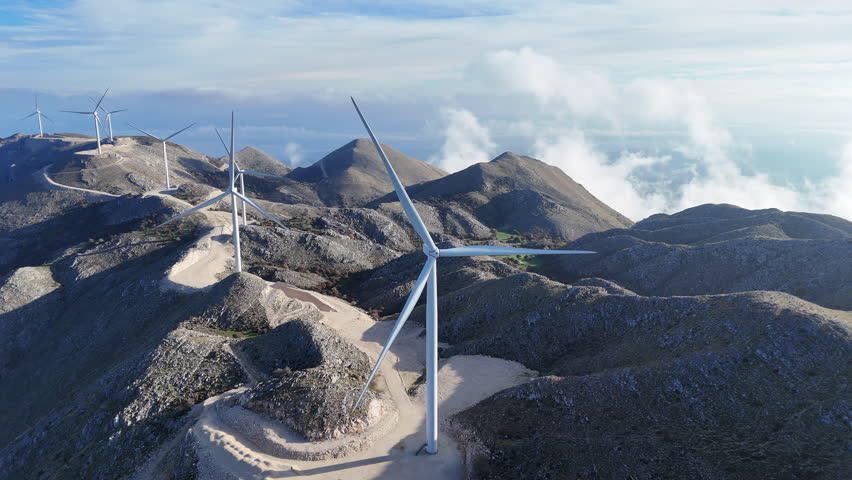 Aerial clip of a mountain top wind farm in morning light.