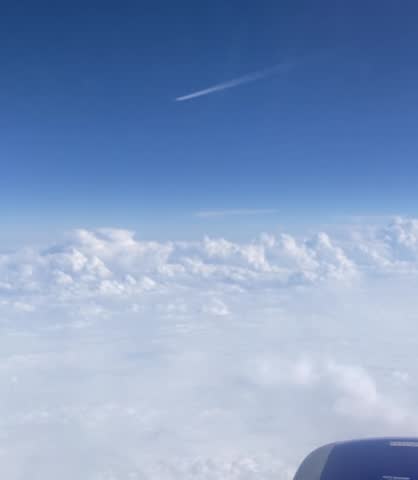 Plane Flying In Blue Sky Over Clouds