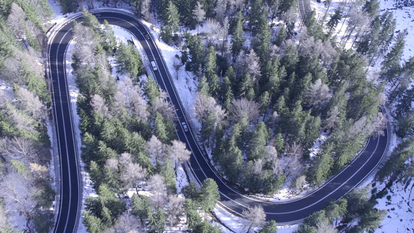 Scenic aerial view of winding road through snowy forest landscape