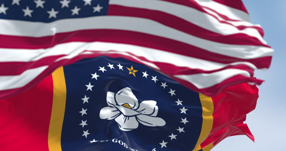 Mississippi state flags waving with the American flag on a clear day. Magnolia state. Seamless 3d render animation. Slow motion loop. Selective focus