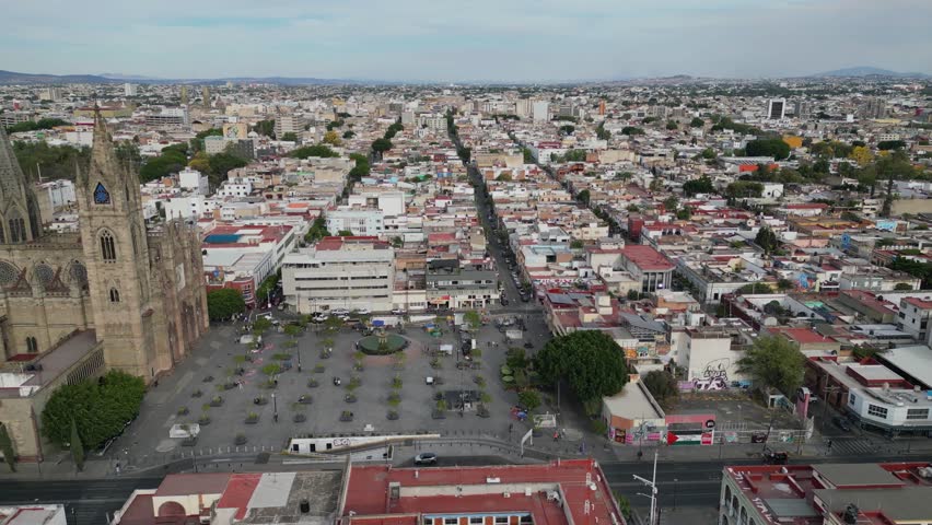 Aerial side movement across Guadalajara showing Templo Expiatorio, MUSA museum and university tower