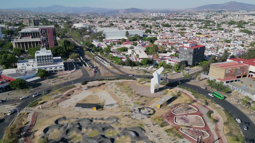 Aerial retreat from La Normal roundabout showing nearby school campus and surrounding neighborhoods