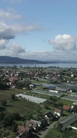 Scenic view of countryside near the lake with farms and buildings under a clear sky