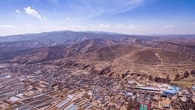 Stunning aerial time lapse view of terraced agricultural landscapes and urban development in Gansu Province, Northwest China, showcasing natural mountain terrain. - Powered by Shutterstock - Get 15% off with code: PIKWIZARD15