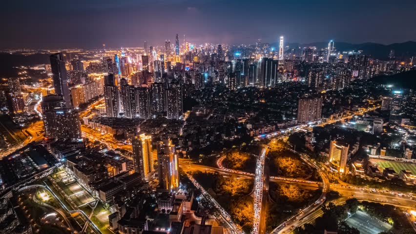 Stunning aerial night view of Shenzhen Luohu district skyline with illuminated skyscrapers, highways, and urban infrastructure creating a vibrant cityscape time lapse scene.