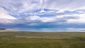 Stunning aerial time lapse footage of magnificent Qinghai Lake with dramatic cloudy sky and vast grassland plateau in China's remote wilderness landscape. - Powered by Shutterstock - Get 15% off with code: PIKWIZARD15