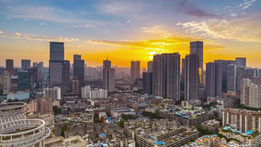 Stunning aerial view of Chengdu city skyline during golden hour sunset with dramatic sky and modern skyscrapers illuminated by warm light