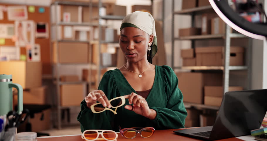 Woman, unboxing and ring light with sunglasses, talk and happy with choice for online audience. African girl, dropshipping and influencer with affiliate marketing, fashion or social media with tech