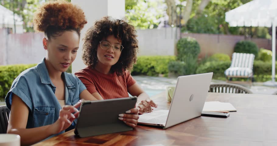 Tablet tapping by marketing designers initiating sparkles then sliding laptop while editing content. Collaboration, friendship, outdoor, leisure, technology, creativity, beauty