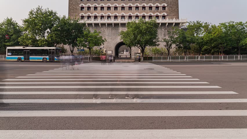 Time lapse view of Zhengyangmen Gate in Beijing with moving crowds and traffic, showcasing historic Chinese architecture and urban life in China
