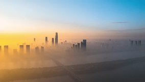 Stunning time lapse view of Changsha city skyline emerging from morning mist at sunrise, with dramatic golden light illuminating skyscrapers and Xiangjiang River area. - Powered by Shutterstock - Get 15% off with code: PIKWIZARD15