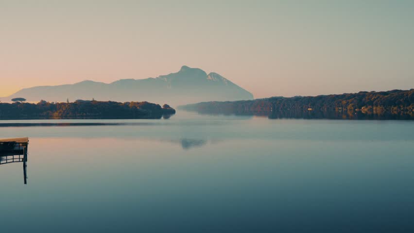 Panoramic view of Lake Paola in Sabaudia at dawn with the Circeo promontory in the background. Calm waters and tranquility, and mist over the lake.