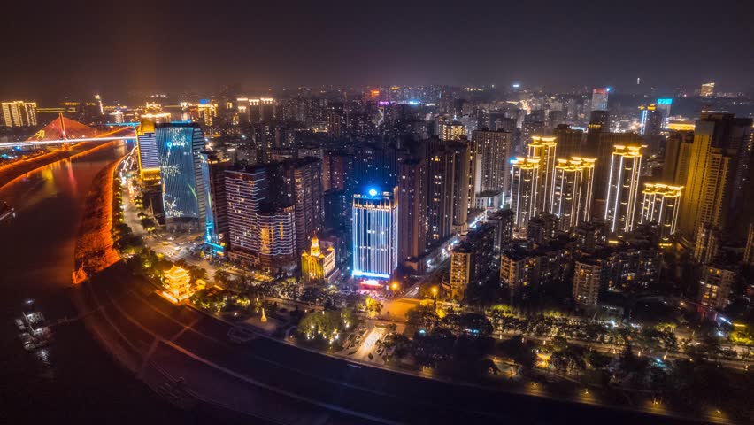 Spectacular aerial night view of Yichang city skyline in Hubei Province, China, showcasing illuminated skyscrapers, modern architecture, and urban development in panoramic detail.