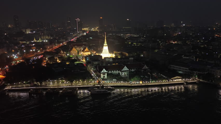 Aerial around view on night lights of Wat Prayurawongsawas Warawihan pagoda, Bangkok, Thailand, 4k