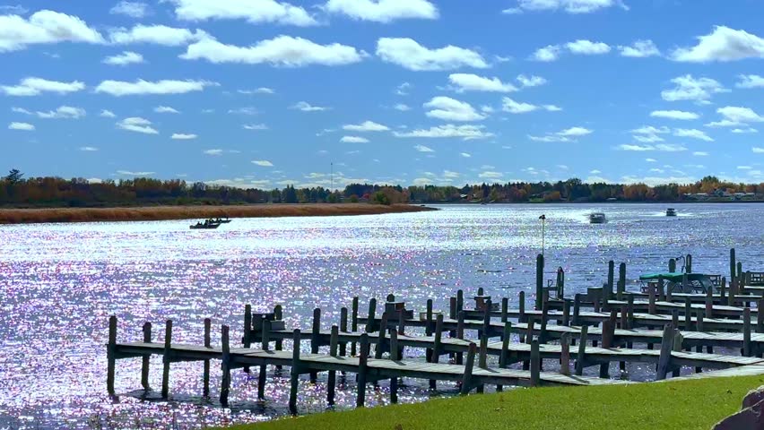 Wooden docks and a few fishing boats on the Rainy River which borders the United States and Canada, near Baudette, Minnesota on a sunny autumn morning.